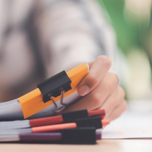 A pile of papers clipped with a file clip.